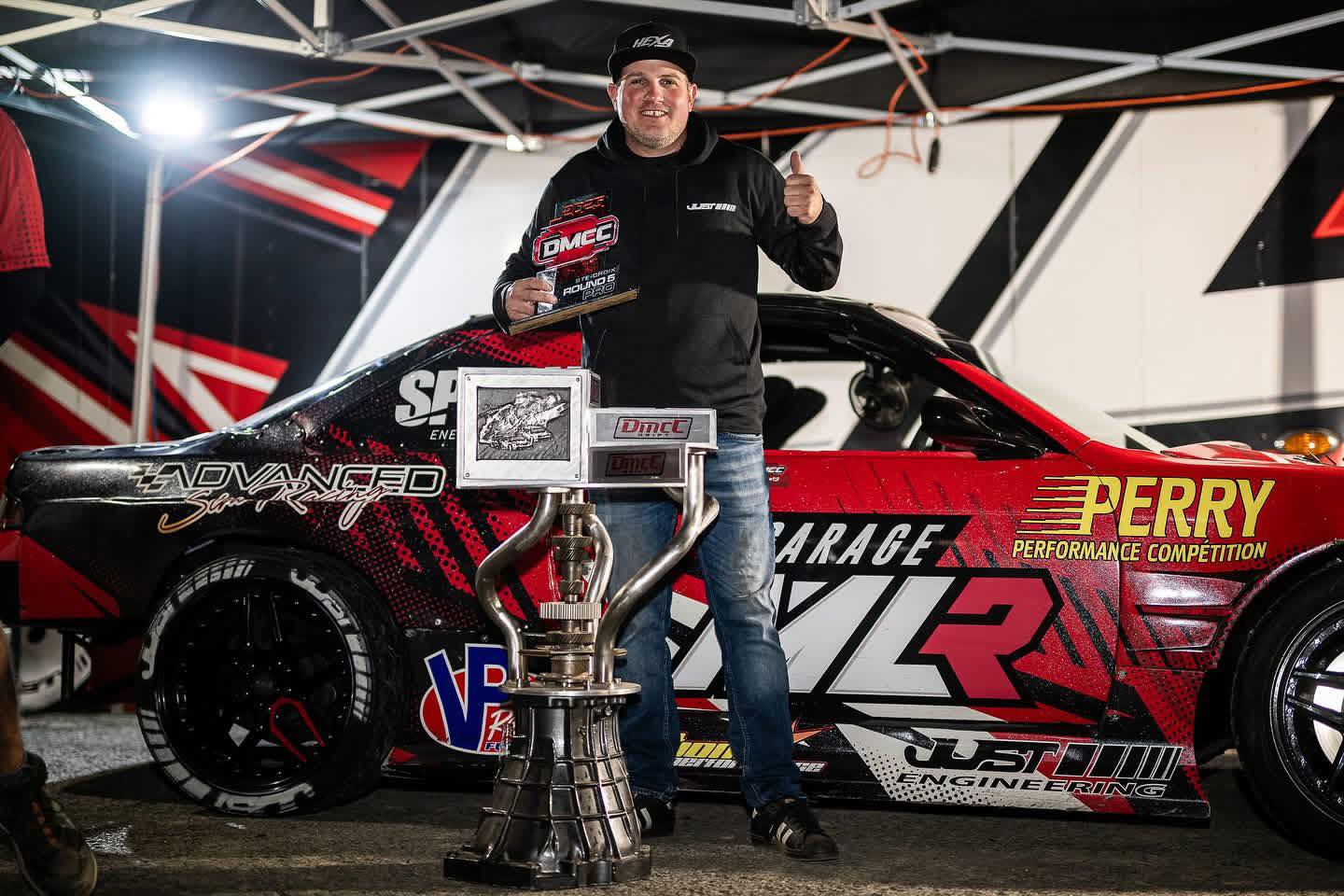 Marc Landreville standing with a trophy beside an MLR drift car